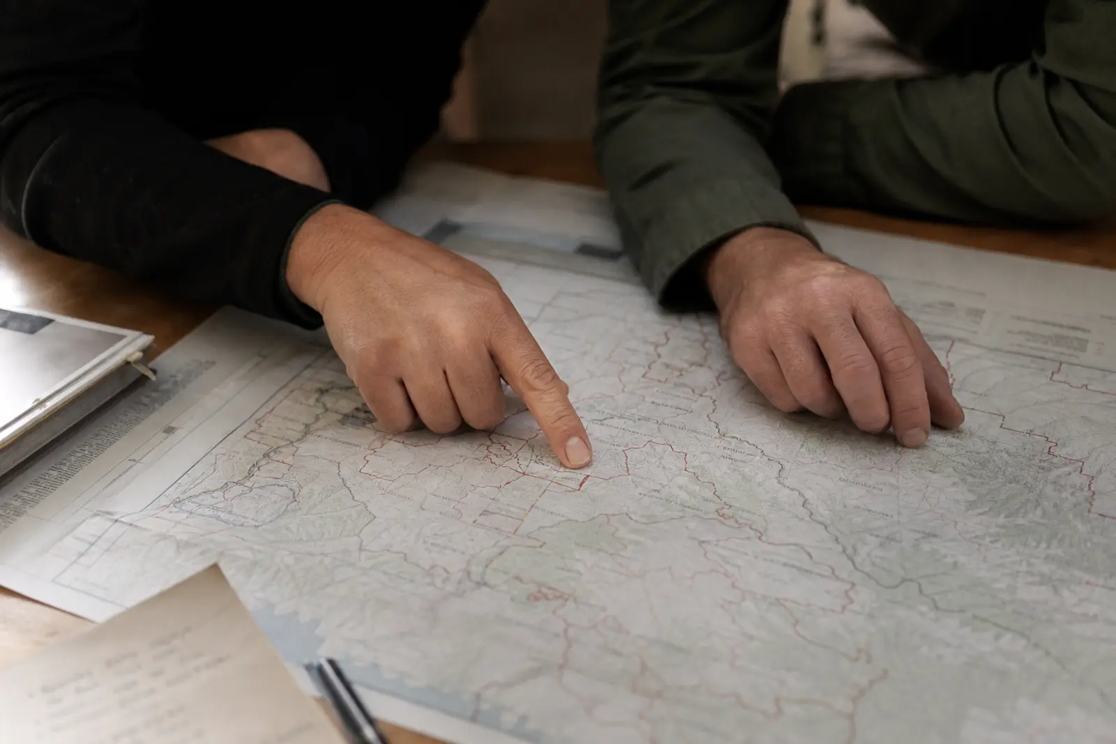 Two practitioners trace a route across a paper map.